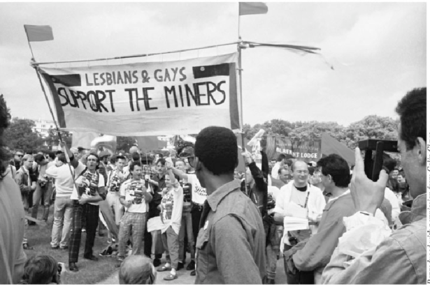Imagen de una manifestación "Lesbians and Gays support the miners", con una pancarta que tiene ese mismo texto.